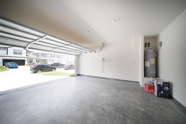 garage with baseboards and electric water heater