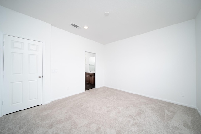 carpeted empty room featuring baseboards and visible vents