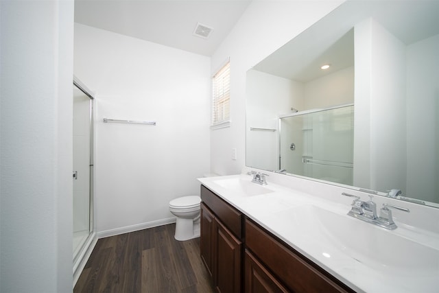 full bathroom featuring toilet, a stall shower, a sink, and wood finished floors