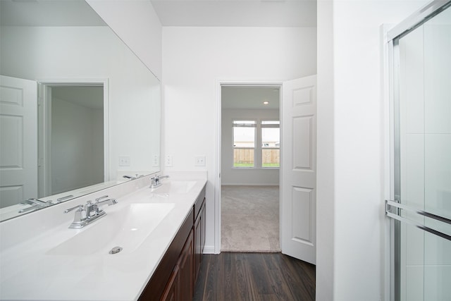 bathroom featuring double vanity, a sink, and wood finished floors