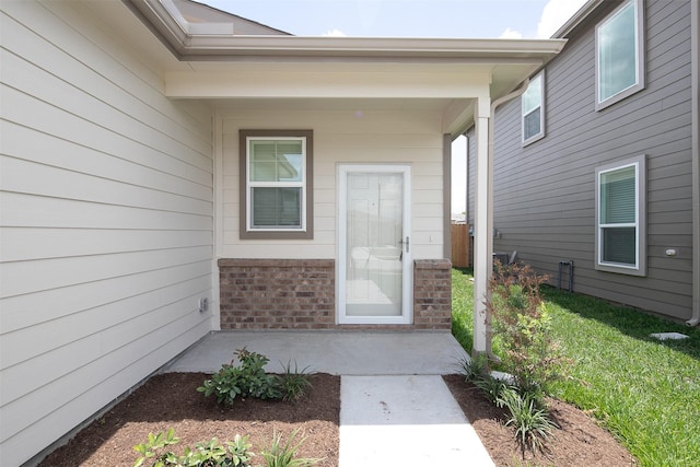 view of exterior entry with brick siding