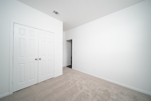 unfurnished bedroom with baseboards, a closet, visible vents, and carpet flooring