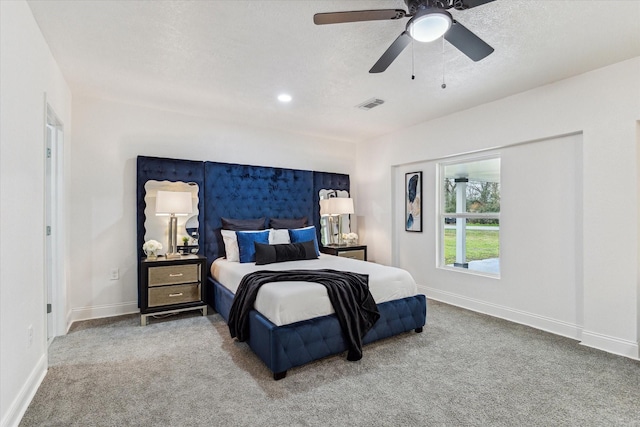 carpeted bedroom with visible vents, baseboards, ceiling fan, and a textured ceiling