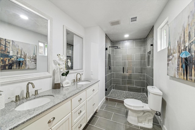 full bath with a stall shower, a sink, toilet, and tile patterned floors