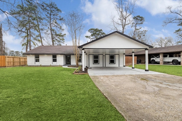 view of front of property featuring brick siding, fence, driveway, a carport, and a front yard