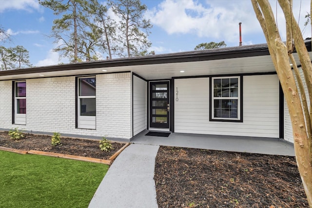 view of front of house featuring covered porch and brick siding