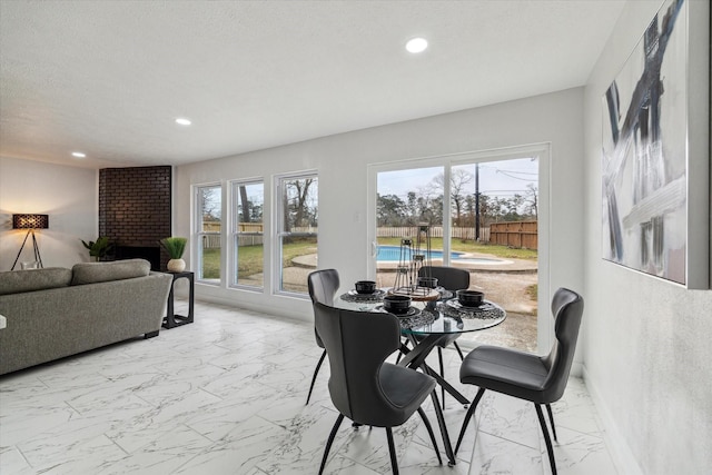 dining area featuring a textured ceiling, marble finish floor, and recessed lighting