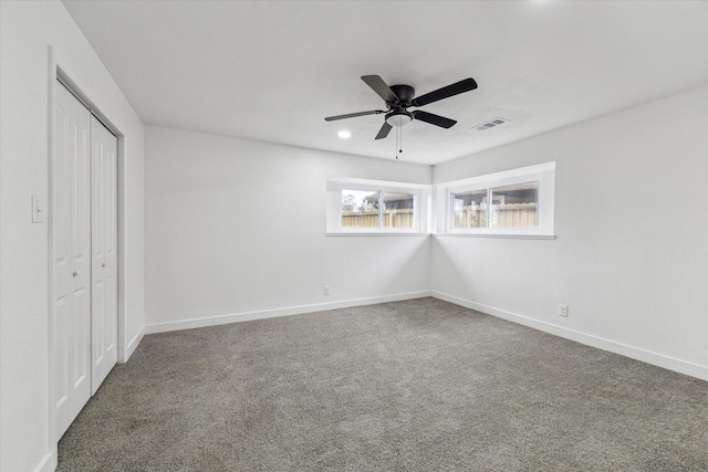 unfurnished bedroom featuring carpet floors, visible vents, baseboards, and a closet