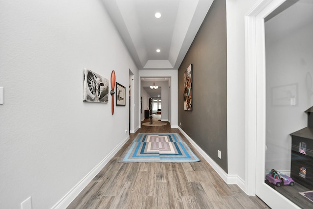 hall with an inviting chandelier, baseboards, wood finished floors, and recessed lighting