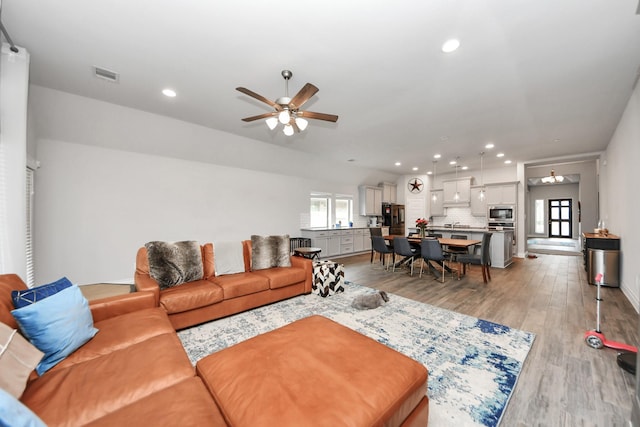 living room featuring light wood-style floors, recessed lighting, visible vents, and ceiling fan