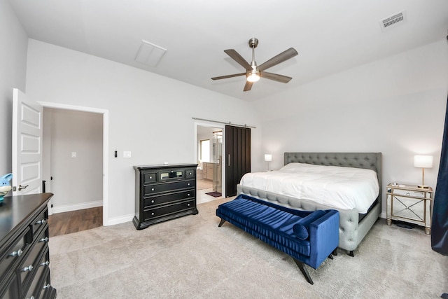 bedroom featuring a barn door, carpet floors, visible vents, baseboards, and vaulted ceiling