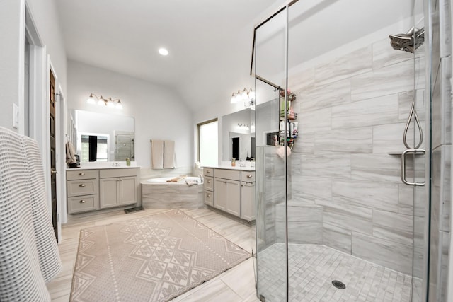 bathroom with a stall shower, a garden tub, and vaulted ceiling