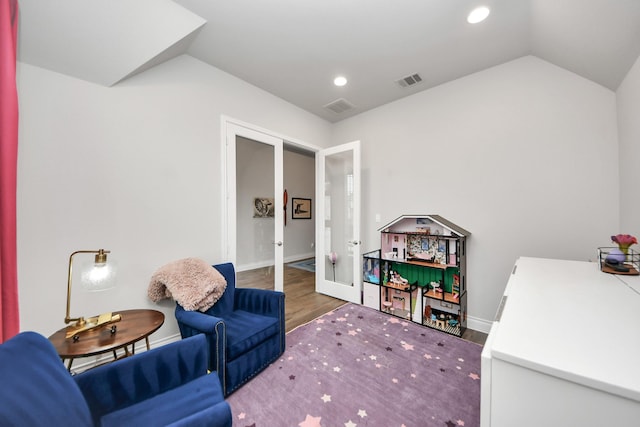 rec room featuring vaulted ceiling, french doors, wood finished floors, and visible vents