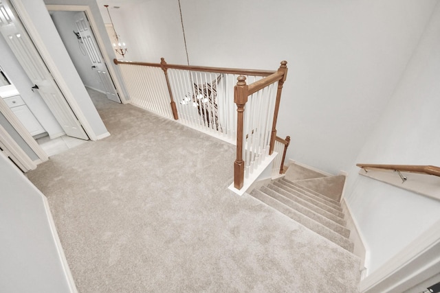 stairway featuring carpet and a chandelier