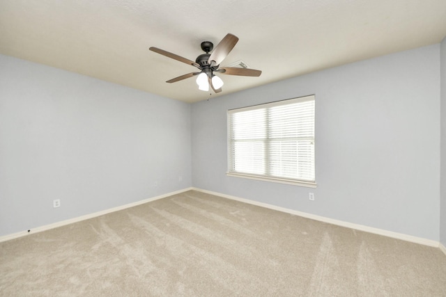 carpeted empty room with a ceiling fan and baseboards