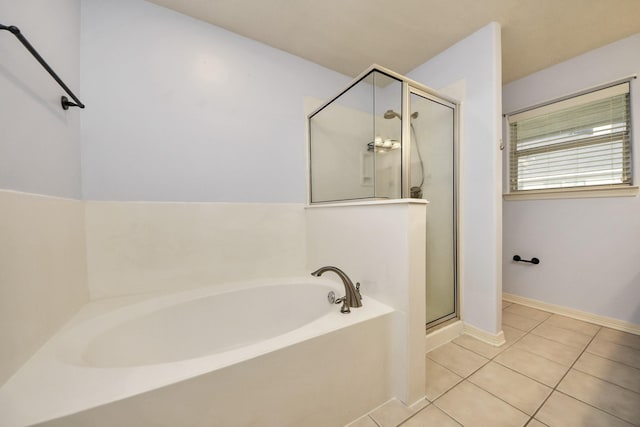 full bath featuring a shower stall, baseboards, a bath, and tile patterned floors