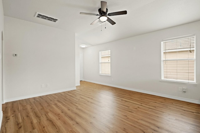 unfurnished room featuring ceiling fan, light wood-style flooring, visible vents, and baseboards