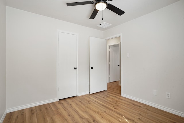 unfurnished bedroom featuring light wood-style flooring, visible vents, baseboards, and a ceiling fan