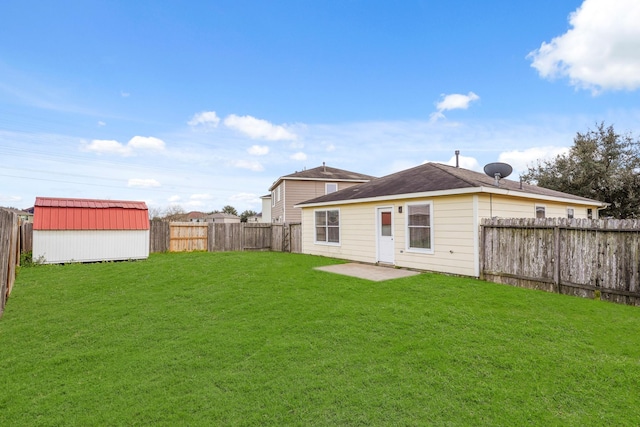 back of house featuring an outbuilding, a fenced backyard, a lawn, and a storage shed