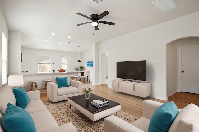 living area with light wood finished floors, visible vents, arched walkways, a ceiling fan, and recessed lighting