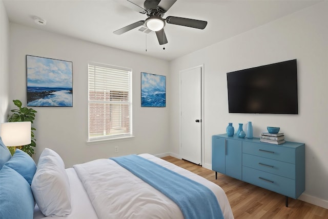 bedroom featuring light wood-style floors, ceiling fan, and baseboards