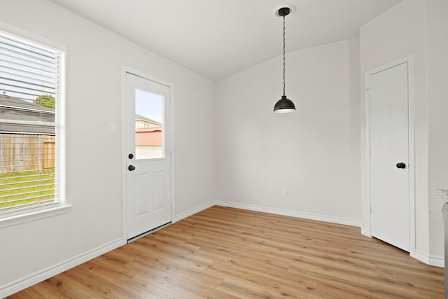 unfurnished dining area featuring light wood finished floors, plenty of natural light, and baseboards