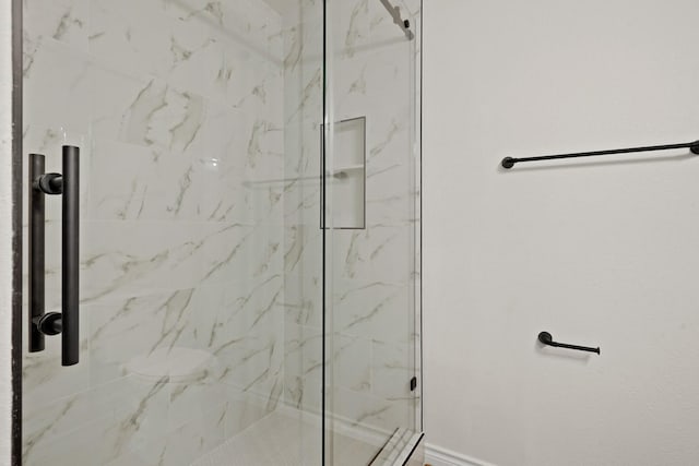 bathroom with a marble finish shower