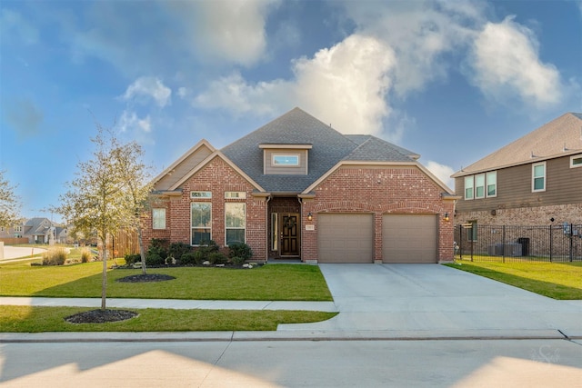 traditional home featuring driveway, a front yard, fence, and brick siding