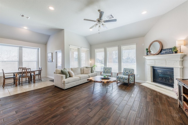 living area featuring lofted ceiling, wood finished floors, and a healthy amount of sunlight