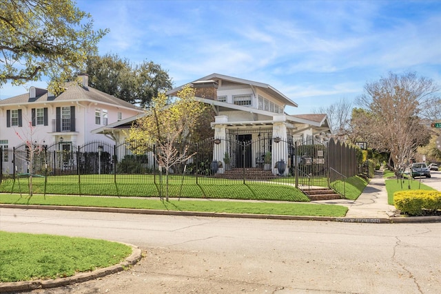 view of front of house with a fenced front yard, a gate, and a front lawn