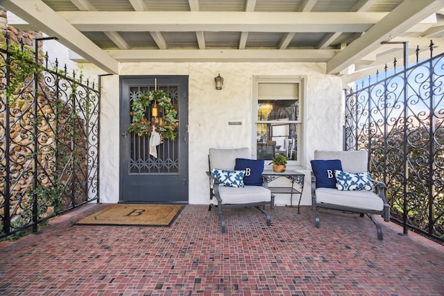 view of exterior entry with a porch and stucco siding