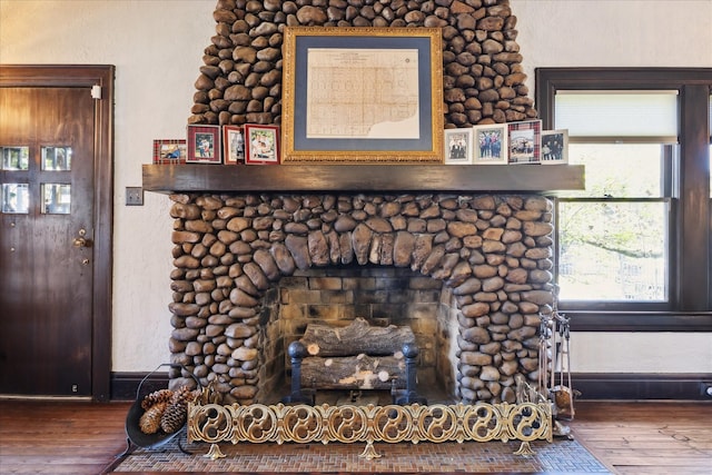 interior details featuring a fireplace, baseboards, and wood finished floors