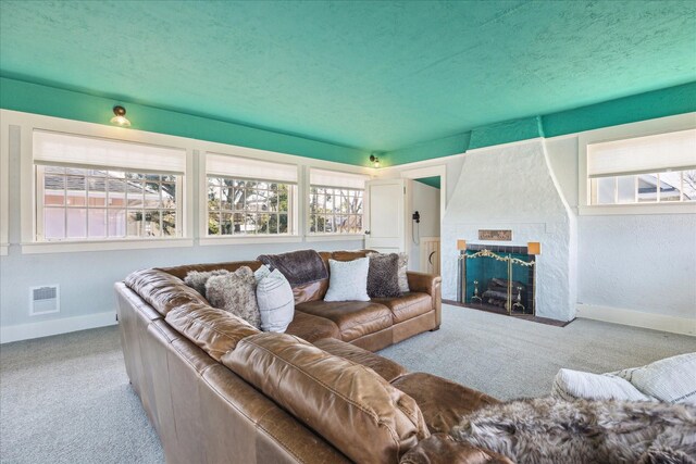 living area featuring visible vents, baseboards, carpet floors, and a fireplace