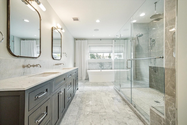 full bath featuring a sink, visible vents, a freestanding bath, double vanity, and a stall shower