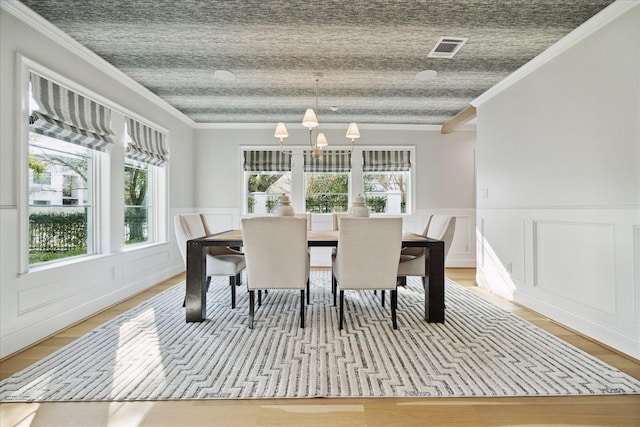 dining area featuring a chandelier, ornamental molding, and visible vents