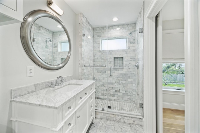 full bath featuring marble finish floor, a stall shower, vanity, and baseboards