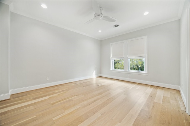 empty room with baseboards, visible vents, and crown molding