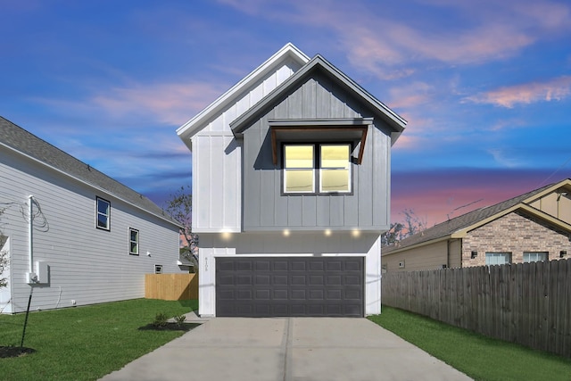 view of front facade with board and batten siding, a yard, fence, and a garage