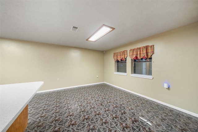 unfurnished room featuring baseboards and visible vents