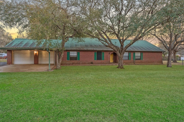 ranch-style home with a garage, a lawn, and metal roof