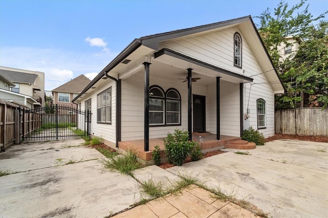 view of front of property featuring a ceiling fan, a gate, a porch, and fence