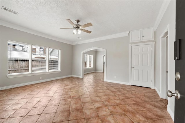 spare room with arched walkways, crown molding, light tile patterned floors, visible vents, and ceiling fan