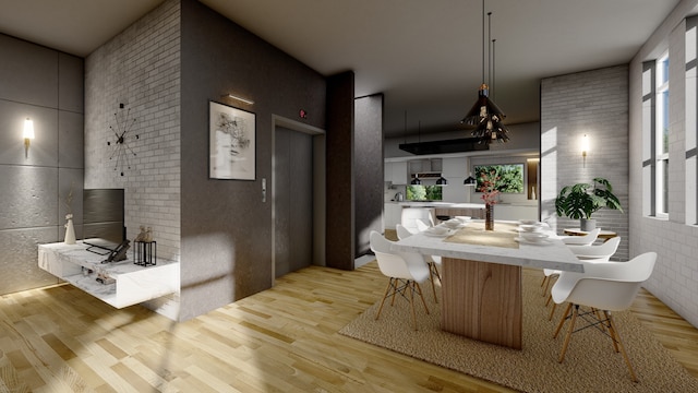 dining room featuring brick wall, wood finished floors, and a healthy amount of sunlight