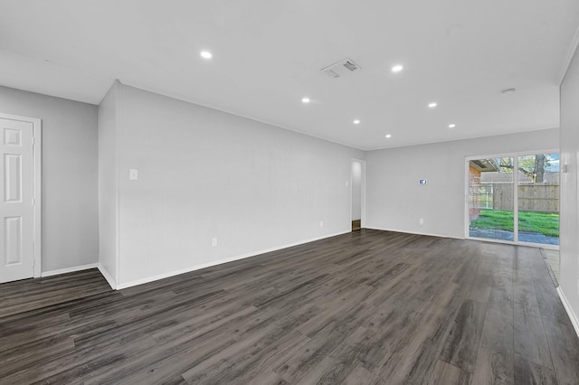 spare room with baseboards, dark wood-type flooring, visible vents, and recessed lighting