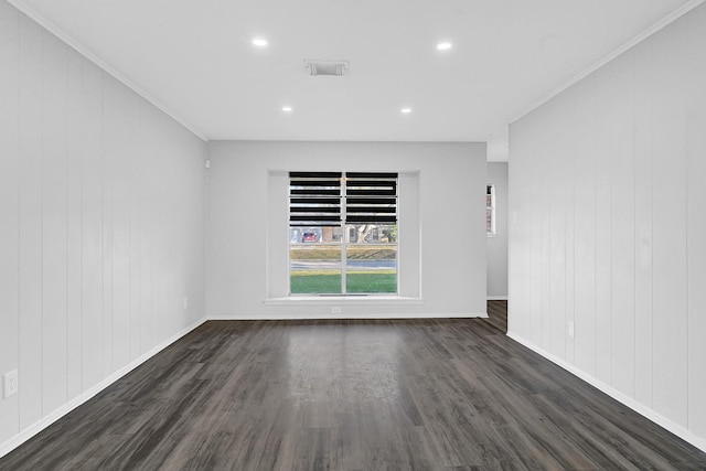 spare room with baseboards, crown molding, visible vents, and dark wood-style flooring