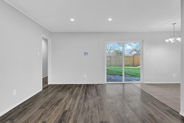 spare room with baseboards, ornamental molding, wood finished floors, an inviting chandelier, and recessed lighting