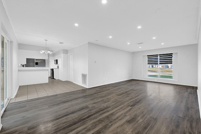 unfurnished living room with dark wood-style floors, visible vents, a notable chandelier, and recessed lighting