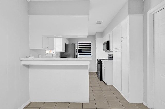 kitchen with visible vents, appliances with stainless steel finishes, a peninsula, light countertops, and white cabinetry