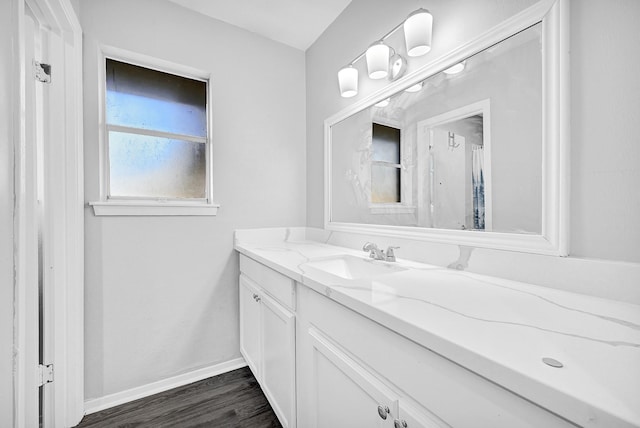 bathroom featuring vanity, baseboards, and wood finished floors