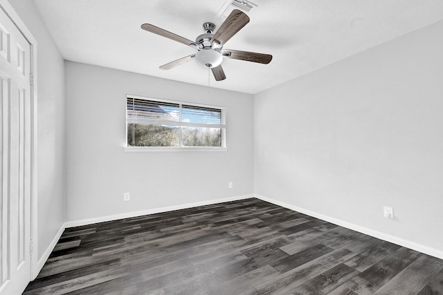 empty room featuring dark wood-style flooring, a ceiling fan, and baseboards